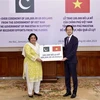 Thứ trưởng Bộ Ngoại giao Đỗ Hùng Việt trao tượng trưng số tiền 100.000 USD cho Đại sứ Pakistan tại Việt Nam Samina Mehtab. (Ảnh: TTXVN phát)