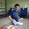 Cử tri bỏ phiếu bầu Quốc hội tại điểm bầu cử ở Athens, Hy Lạp ngày 25/6. (Ảnh: AFP/TTXVN)