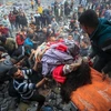 Chuyển người thiệt mạng trong cuộc không kích của Israel tại Dải Gaza. (Ảnh: IRNA/TTXVN)
