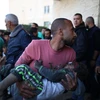 Chuyển một em nhỏ bị thương trong cuộc không kích của Israel vào bệnh viện ở thành phố Deir el-Balah, Dải Gaza, ngày 11/12. (Ảnh: THX/TTXVN)