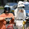 Người dân mặc áo chống nắng bảo vệ trong thời tiết nắng nóng gay gắt tại Thượng Hải, Trung Quốc, ngày 29/5/2023. (Ảnh: AFP/TTXVN)