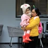 Một em bé được mẹ mặc áo ấm khi ra ngoài đường. (Ảnh: Tuấn Anh/TTXVN)