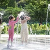 Trẻ em giải nhiệt dưới đài phun nước tại Daegu, Hàn Quốc. (Ảnh: Yonhap/TTXVN)