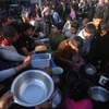 Người dân chờ được phát thực phẩm cứu trợ tại thành phố Rafah, Dải Gaza. (Ảnh: THX/TTXVN)