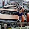 Công nhân làm việc bên trong nhà máy ở Sơn Đông, Trung Quốc. (Ảnh: THX/TTXVN)