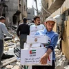 Người dân nhận hàng viện trợ nhân đạo tại Dải Gaza. (Ảnh: AFP/TTXVN)