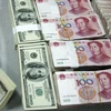 Nhân viên kiểm đồng USD và nhân dân tệ tại một ngân hàng ở tỉnh An Huy, Trung Quốc. (Ảnh: AFP/TTXVN)