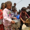 Trẻ em nhận thực phẩm cứu trợ tại thành phố Rafah, Dải Gaza ngày 19/5. (Ảnh: THX/TTXVN)
