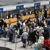 Hành khách tại sân bay Stuttgart ở Leinfelden-Echterdingen, Đức. (Ảnh: AFP/TTXVN)