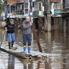 Người dân di chuyển qua vùng ngập lụt tại Porto Alegre, bang Rio Grande do Sul, Brazil, ngày 29/5. (Ảnh: AFP/TTXVN)