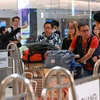 Hành khách rời máy bay của Hãng hàng không Singapore Airlines, sau khi máy bay phải hạ cánh khẩn cấp xuống Bangkok (Thái Lan) ngày 21/5 do gặp sự cố nhiễu động không khí. (Ảnh: AFP/TTXVN)