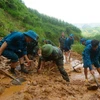 Cán bộ, chiến sỹ Ban Chỉ huy Quân sự huyện Mèo Vạc cùng lực lượng dân quân khơi thông tuyến đường vào thôn Khuổi Roài, xã Tát Ngà bị cô lập do mưa lũ. (Ảnh: Hà Linh/TTXVN phát)