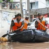 Cảnh sát Trung Quốc giúp sơ tán người dân khỏi các khu vực ngập lụt. (Ảnh: AFP/TTXVN)