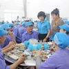 Lãnh đạo Liên đoàn Lao động Khánh Hòa thăm hỏi công nhân, đoàn viên công đoàn của Công ty In bao bì Khatoco trong "Bữa cơm Công đoàn." (Ảnh: Phan Sáu/TTXVN)