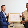 Tham tán Công sứ Chu Tuấn Đức tặng kỷ niệm chương ông Nguyễn Ngọc Chiến, thương binh tại chiến trường Quảng Trị. (Ảnh: Phương Hoa/TTXVN)