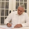 Bí thư thứ Nhất Ban Chấp hành Trung ương Đảng, Chủ tịch Cuba Miguel Díaz-Canel Bermúdez ghi sổ tang. (Ảnh: Việt Hùng/TTXVN)