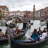 Du khách đi thuyền gondola tại Venice, Italy. (Ảnh: AFP/TTXVN)