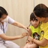 Nhân viên y tế quận Hoàn Kiếm tiêm vaccine cho trẻ tại điểm tiêm phường Phúc Tân. (Ảnh: Vân Chi/TTXVN phát)