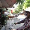 Lực lượng chức năng tại Thị trấn Phùng, huyện Đan Phượng, Hà Nội kiểm soát chặt chẽ người đi chợ dịp nghỉ lễ Quốc khánh. (Ảnh: Minh Quyết/TTXVN)