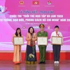 Thứ trưởng Bộ Giáo dục và Đào tạo Ngô Thị Minh trao bằng khen cho các tác giả đạt giải nhất. (Ảnh: Thanh Tùng/TTXVN)