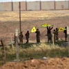 Binh sỹ người Kurd giương cờ sau khi chiếm được cửa khẩu Akcakale trên biên giới Syria - Thổ Nhĩ Kỳ ngày 15/6. (Nguồn: AFP/TTXVN) 