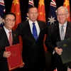 Bộ trưởng Thương mại Trung Quốc Cao Hổ Thành (trái), Thủ tướng Australia Tony Abbott (giữa) và Bộ trưởng Thương mại Australia Andrew Robb (phải) tại lễ ký kết. (Nguồn: AFP/TTXVN)