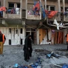 Nhân viên dọn dẹp sau vụ đánh bom ở quận Bayaa. (Nguồn: AFP/TTXVN) 