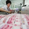 Kiểm tiền nhân dân tệ tại ngân hàng ở Liên Vận Cảng, tỉnh Giang Tô, Trung Quốc ngày 11/8. (Nguồn: THX/TTXVN) 