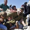 Người lính Israel bị gia đình cậu bé tấn công. (Nguồn: RT)