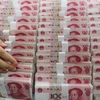 Kiểm tiền giấy mệnh giá 100 nhân dân tệ tại ngân hàng ở Liên vận cảng, tỉnh Giang tô, Trung Quốc. (Nguồn: AFP/TTXVN) 