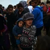 Người tị nạn và di cư xếp hàng đợi nhận khẩu phần ăn tại trại tị nạn. (Nguồn: AFP/TTXVN)
