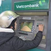 Một nữ công nhân đến rút tiền tại ATM Vietcombank. (Ảnh: Mạnh Minh/TTXVN) 
