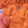 Nhà điêu khắc Marielle Heessels (Hà Lan) đang thực hiện điêu khắc một tác phẩm tượng cát. (Ảnh: Nguyễn Thanh/TTXVN)