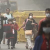 Người dân đeo khẩu trang để tránh tác hại của khói mù ô nhiễm ở New Delhi, Ấn Độ ngày 6/11. (Nguồn: AP/TTXVN) 