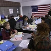 Nhân viên tình nguyện giúp đỡ những người nhập cư hoàn thành các thủ tục xin nhập quốc tịch Mỹ tại New York ngày 4/3. (Nguồn: AFP/TTXVN) 