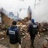 Các quan sát viên OSCE kiểm tra một tòa nhà bị phá hủy sau vụ nã pháo tại Avdiivka. (Nguồn: EPA/TTXVN) 