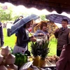 Thực khách đội mưa để thưởng thức các món ăn Việt. (Ảnh: Quang Vinh/TTXVN)