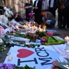 Người dân đặt hoa và thắp nến tại lễ tưởng niệm các nạn nhân vụ tấn công khủng bố ở Manchester. (Nguồn: EPA/TTXVN)