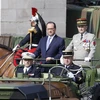 Tổng thống Pháp Francois Hollande (trái) duyệt binh trong lễ kỷ niệm ở Paris. (Nguồn: AFP/ TTXVN)
