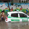 Chiếc xe taxi Thành Lợi nổi lềnh bềnh trong biển nước. (Ảnh: Minh Sơn/Vietnam+)