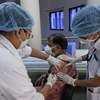Tiêm vắcxin ngừa COVID-19 cho một nhân viên y tế tại Ahmedabad, Ấn Độ (Ảnh: AFP/TTXVN)