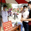 Du khách thực hiện kiểm tra thân nhiệt trước khi vào dâng lễ tại đền Bảo Hà. (Ảnh: Quốc Khánh - TTXVN) 