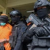 Cảnh sát áp giải nghi phạm khủng bố tại Makassar, Indonesia. (Ảnh: AFP/TTXVN)