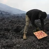 Anh David Garcia nướng pizza trên dung nham từ núi lửa Pacaya ở San Vicente Pacaya, Guatemala ngày 11/5/2021. (Ảnh: AFP/TTXVN)