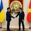 Ông Nguyễn Văn Khanh (trái) nhận quyết định từ Đại sứ đặc mệnh toàn quyền nước CHXHCN Việt Nam tại Ukraine, kiêm nhiệm Moldova Nguyễn Hồng Thạch. (Ảnh: TTXVN phát)