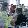Nhân viên y tế tiêm vaccine phòng COVID-19 cho người dân tại thủ đô Vientiane của Lào (Ảnh: THX/TTXVN)