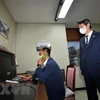 Bộ trưởng Thống nhất Hàn Quốc Lee In-young (phải) thăm phòng đặt đường dây nóng liên lạc với Triều Tiên tại làng biên giới Panmunjom ở Khu phi quân sự giữa hai miền Triều Tiên. (Ảnh: AFP/TTXVN)