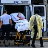Nhân viên y tế chuyển bệnh nhân nhiễm COVID-19 tới bệnh viện ở Miami, Mỹ. (Ảnh: AFP/TTXVN) 
