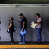 Người đàn ông xem điện thoại khi đứng đợi tiêm vaccine ở thành phố Mexico, Mexico hồi tháng 7. (Ảnh: Reuters.)