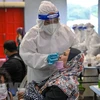 Nhân viên y tế lấy mẫu xét nghiệm COVID-19 cho người dân tại Kuala Lumpur, Malaysia. (Ảnh: AFP/TTXVN) 